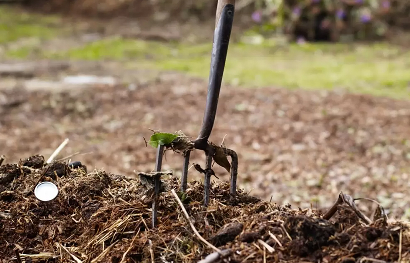 Pitchfork in ground soil pile