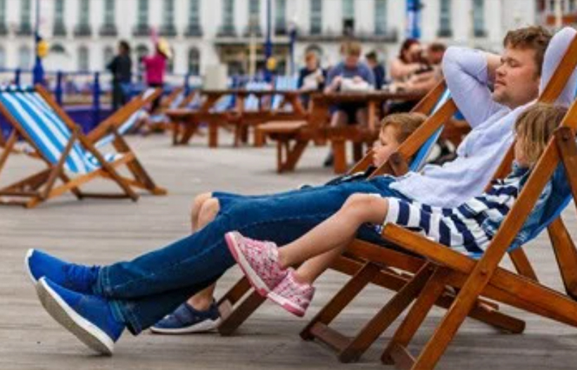 Parent and children relaxing on deck chairs