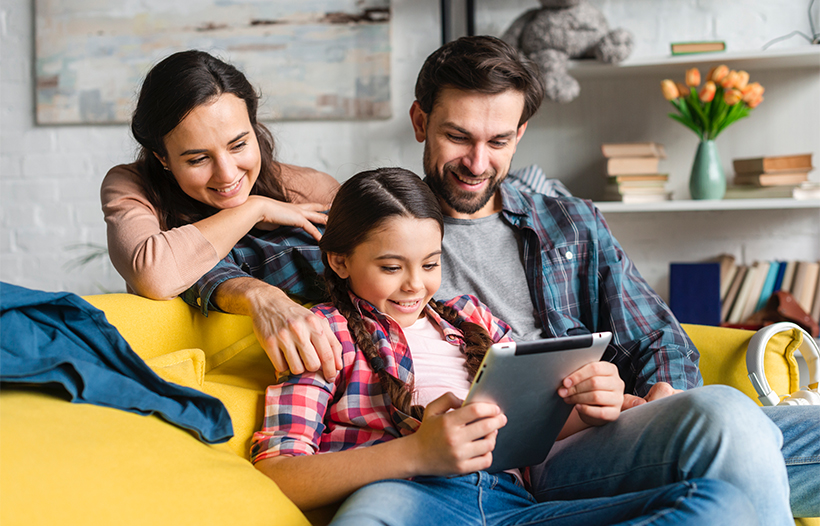 Parents and child looking at tablet device