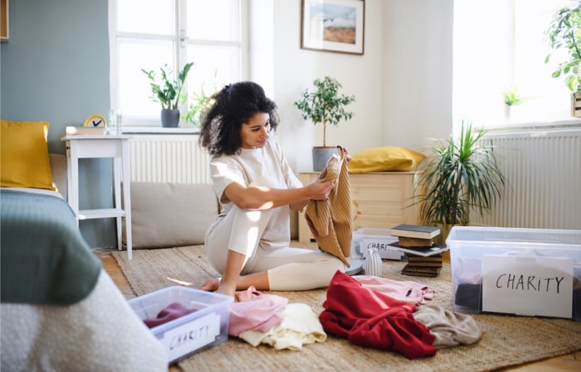 Lady sorting out clothes piles and boxes