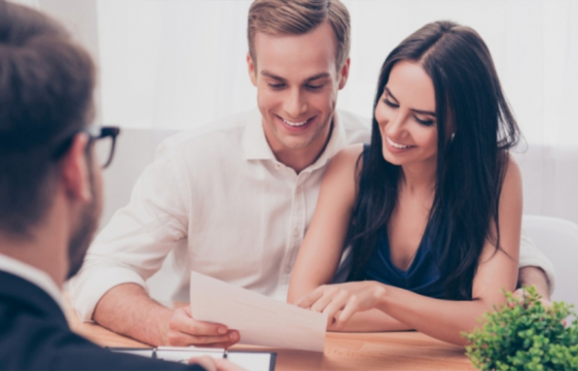 Couple looking at paperwork with financial advisor
