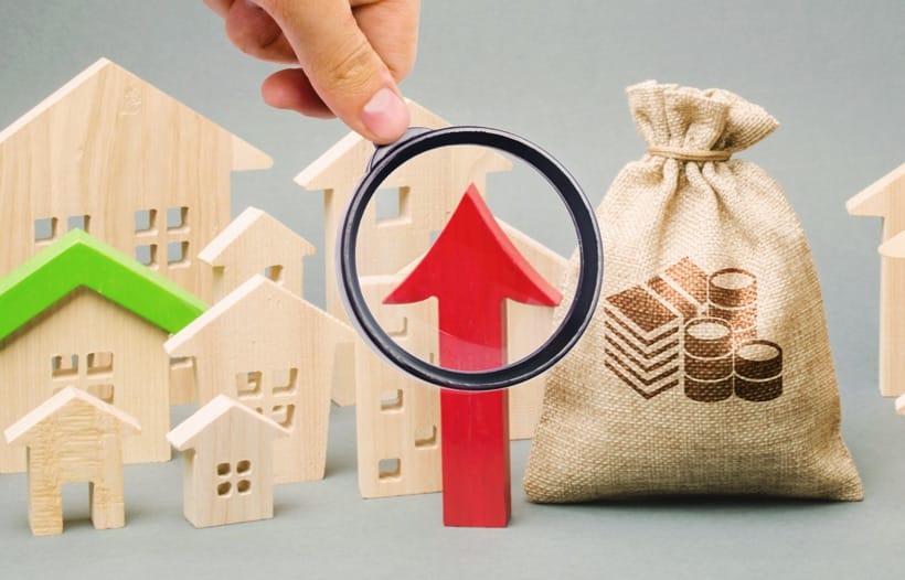 Hand holding magnifying glass looking at wood blocks