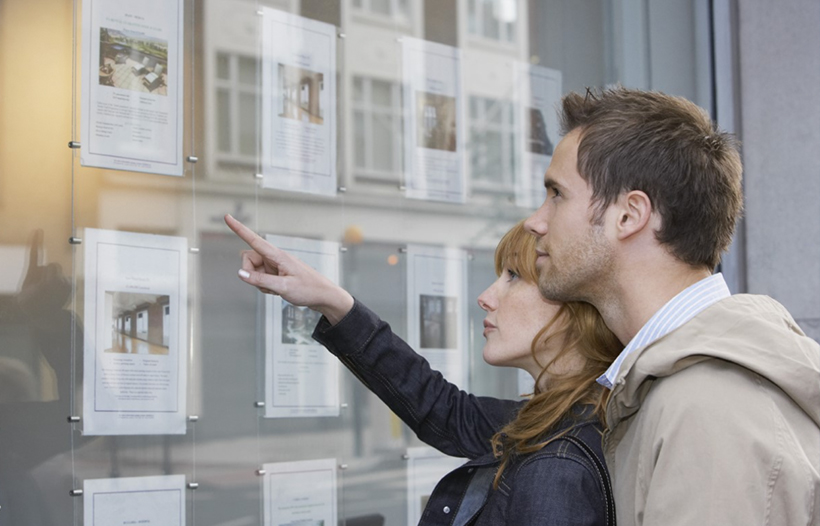 Couple looking at property specification in windows
