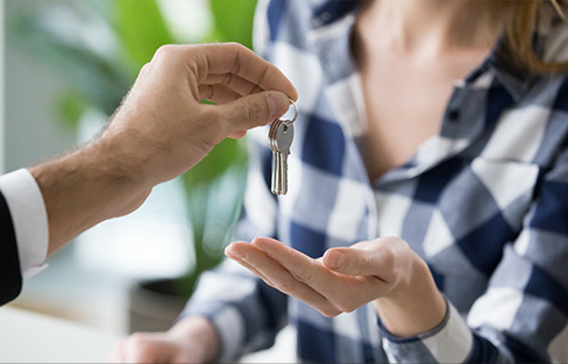 Estate Agent handing over heys to lady