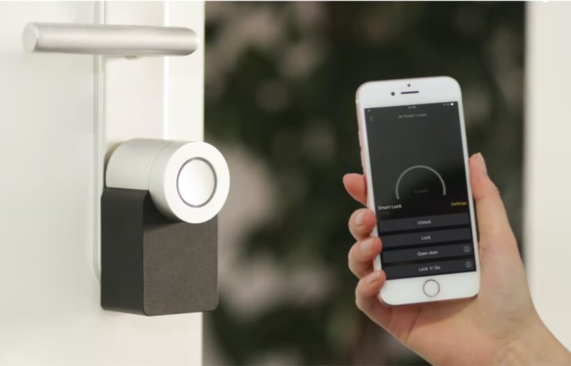 Hand holding smartphone controlling household tech