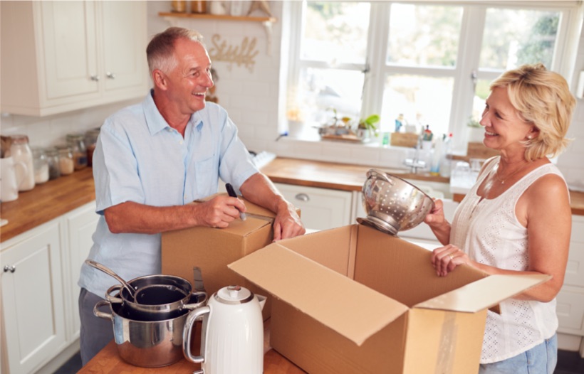 Elderly couple unpacking kitchen utensils