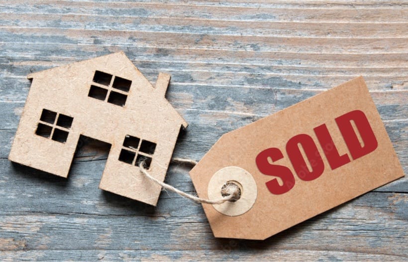 Cardboard house cutout with Sold tag