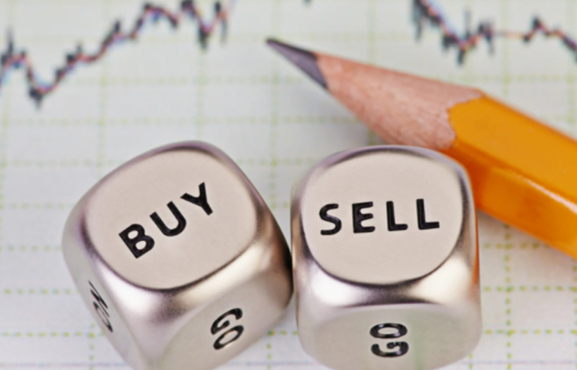 Buy Sell dice and pencil leaning on graph paper