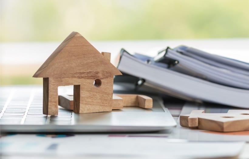 House wooden block next to books