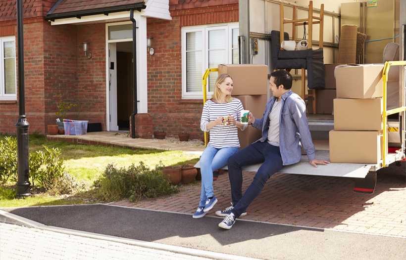 Couple sitting on the back of removal van