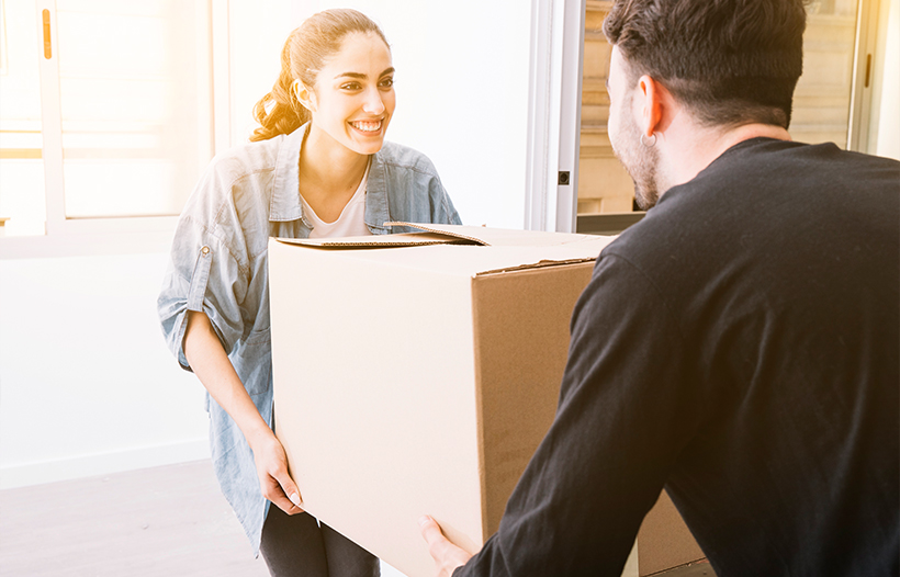 Couple carrying boxes into new property