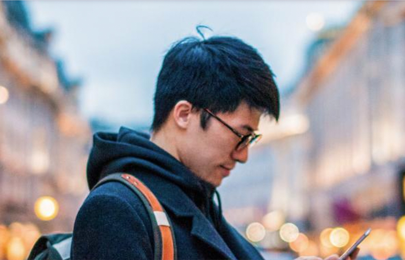 Person looking at phone crossing the road